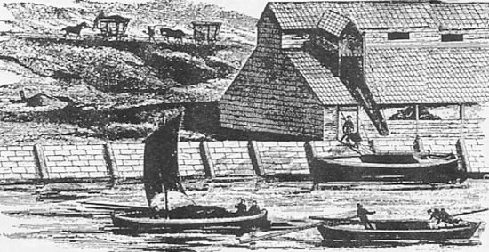 Keel boats, showing one being loaded from a “spout”. On the tracks behind the building, a full truck (“chaldron”) is going by gravity down the track from the mine (with a man on the brake and the horse tied behind) and the empty truck being pulled back up. A similar system was used in the Ringstead Quarry at the end of the 19th Century. (Sunniside Local History Society.)