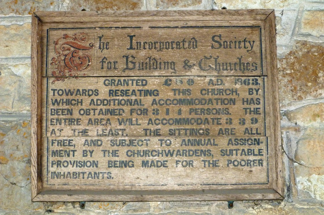 Wooden notice in North Porch of Ringstead Church recording that a grant of £80 had been given for the reseating of the church in 1863. It appears to be a standard notice with the local numbers inserted later. The old box pews had gone but the new open "free" pews were still "allocated", one suspects, along class lines. Author’s own photograph