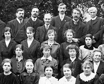 Reverend Neely (top right) and Mrs Neely (middle of 2nd row with large white collar). Taken from photograph of Milton Malsor Church Choir 1916. With the kind permission of Milton Malsor Historical Society ().