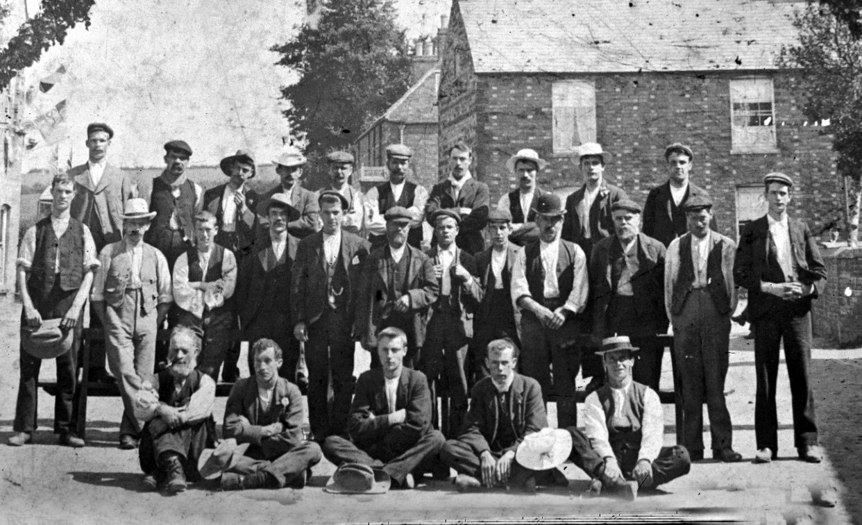 Group of men who have probably just put up a garlanded arch for the Coronation of Edward VII in 1902. I have enlarged the picture to show men’s faces but have lost the arch as a result. From the Ringstead photographic archive held by Peter Davies