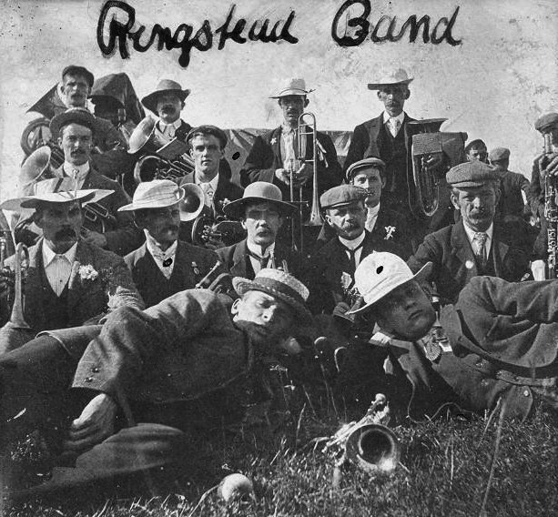 The Ringstead Band included many from the Mayes family. Back Row in the middle, holding a trombone, is Len Mayes; the two men on the left of the second row down are Benny and Ernest Mayes; the man, second left, on third row down is Harry Abbott Mayes. On the right of the front row, lying down, is Bill Mayes who later emigrated to Australia. Behind him on the right holding a flute is Benjamin Ebenezer Roberts